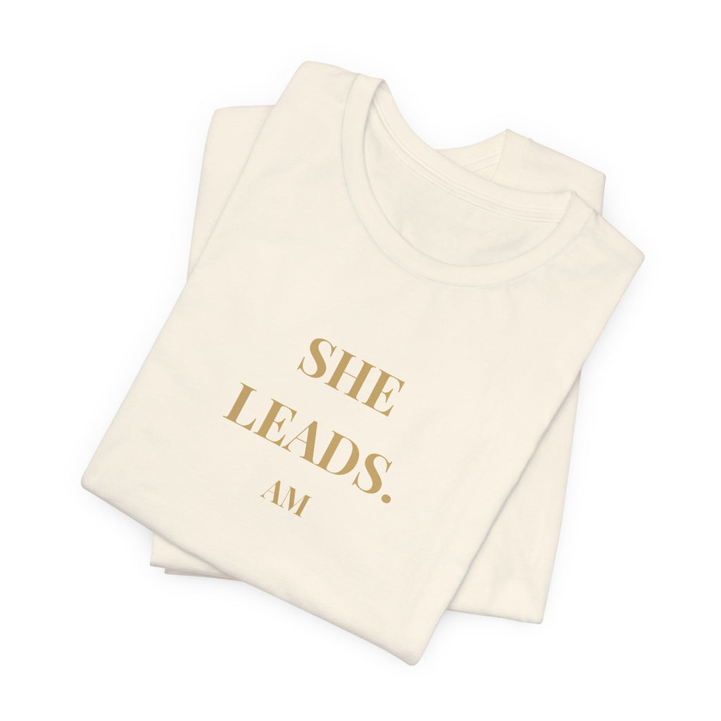 She Leads — Feminine Gold Script Leadership Tee
